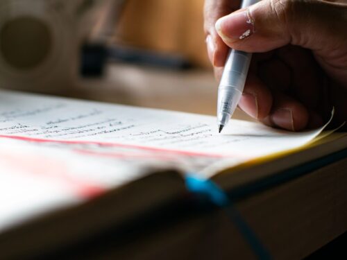 Stock Profit Calculator Close-up Hand Writing Notes with Pen in Notebook - Student Study Session and Academic Learning Process.
