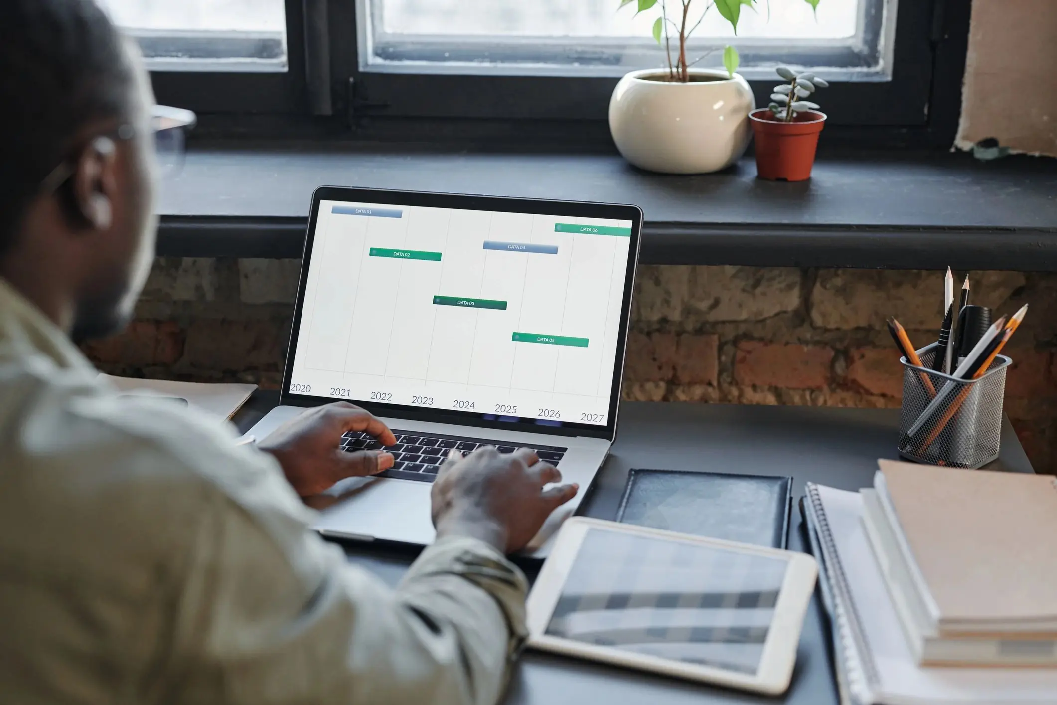 Trader working at desk with stock data on laptop