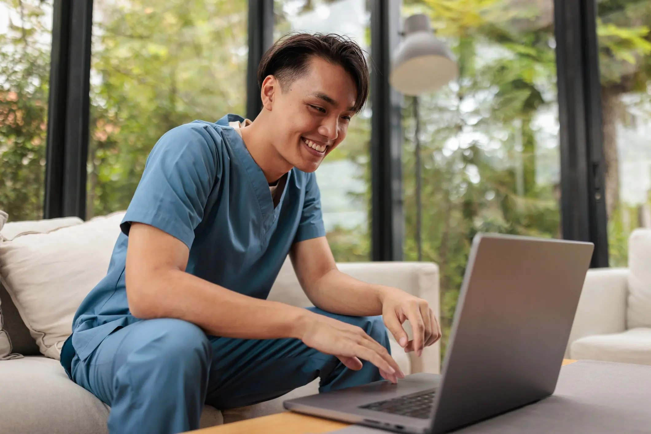 Young man using a laptop at home while reading online content