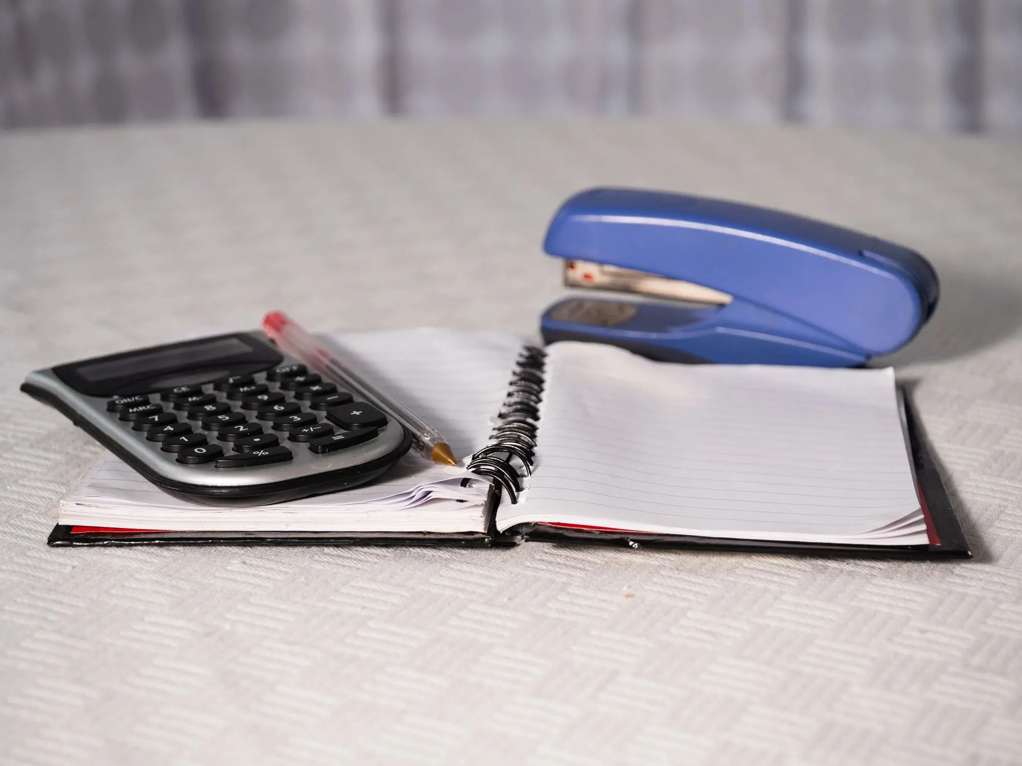 Notepad paper blowing in office with calculator