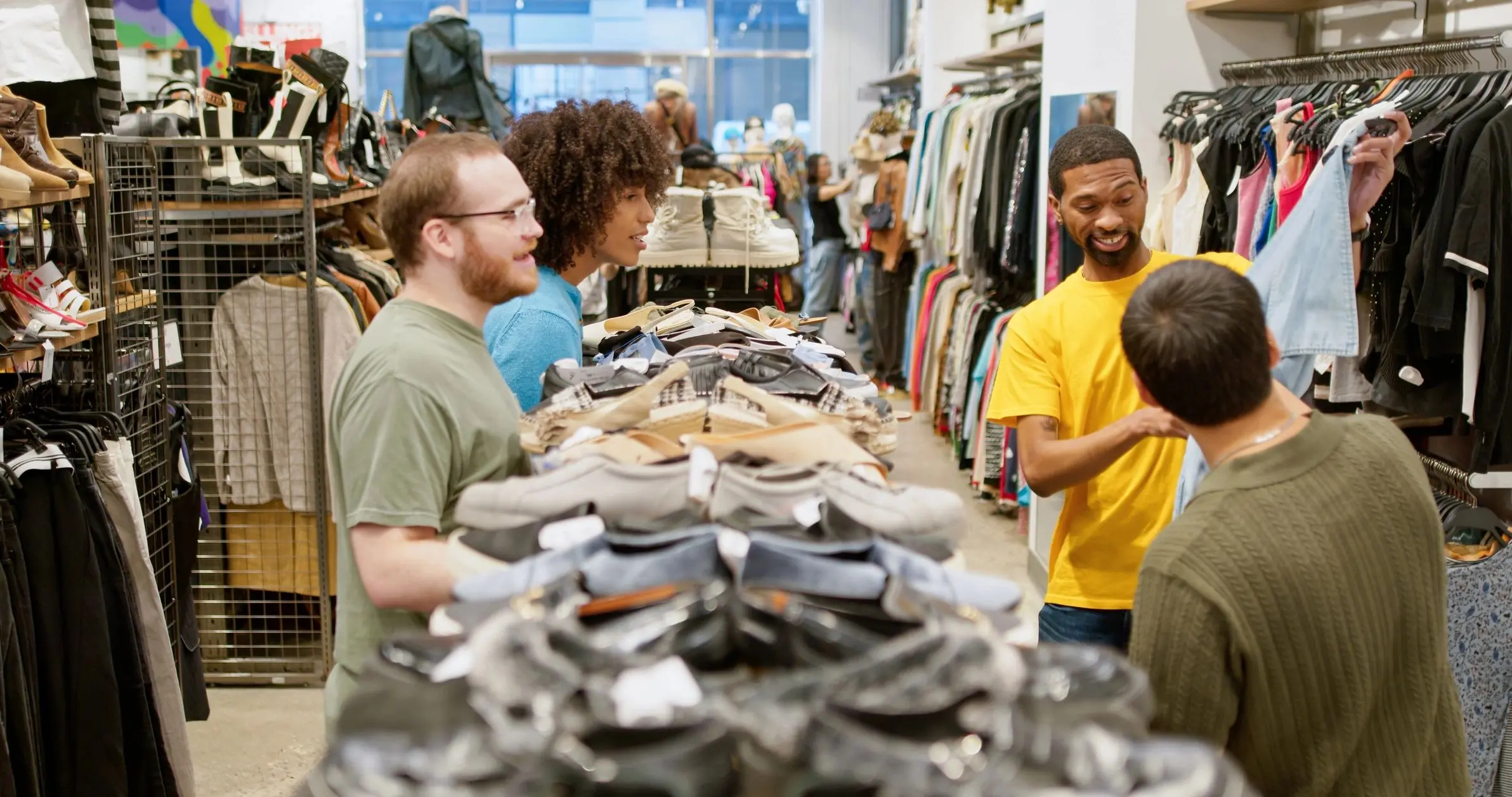 African American man showing denim pants to friends in a clothing store